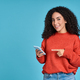 Young happy excited latin woman pointing at mobile phone isolated on blue. - PhotoDune Item for Sale