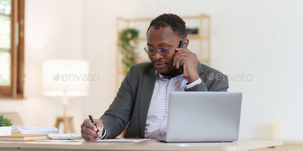Smiling American African Banker or Accountant talking phone with client and makes financial report - Stock Photo - Images