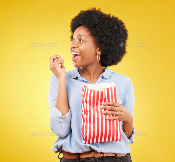 Happy, eating and popcorn with black woman in studio for movie, streaming service and cinema. Telev