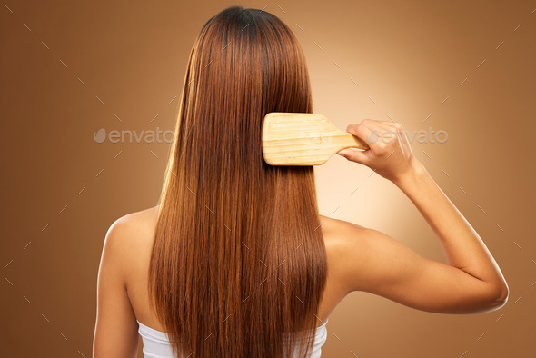Back of hair, brush and woman in studio for beauty, wellness and keratin treatment on brown backgro