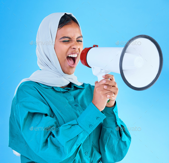 Young woman, muslim and megaphone in studio for protest, human rights and scream by blue background