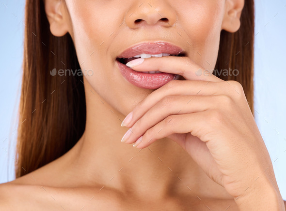 Skincare, mouth and woman biting finger in studio zoom isolated on blue background for lip care. Na