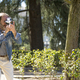 attractive middle-aged photographer taking pictures in the park with a vintage camera - PhotoDune Item for Sale