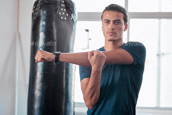 Serious, stretching arm and man in gym ready to start workout, training or exercise. Sports fitness - Stock Photo - Images