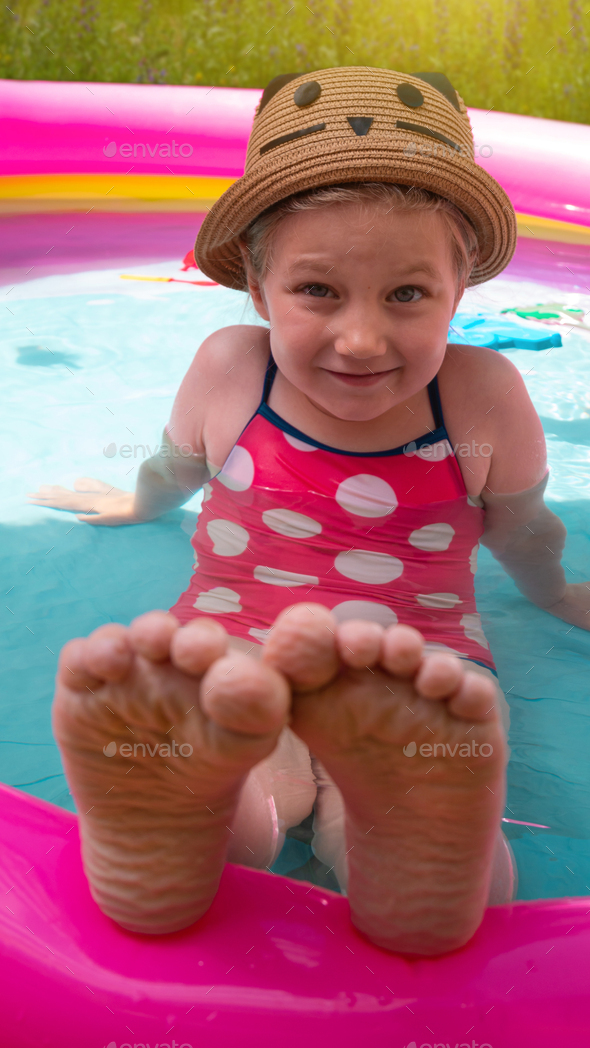 Young girl playing in colorful inflatable swimming pool water.Child in  straw hat and pink swimsuit Stock Photo by Kawaii-S