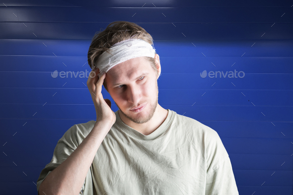 a male person with injured head, white bandage on forehead