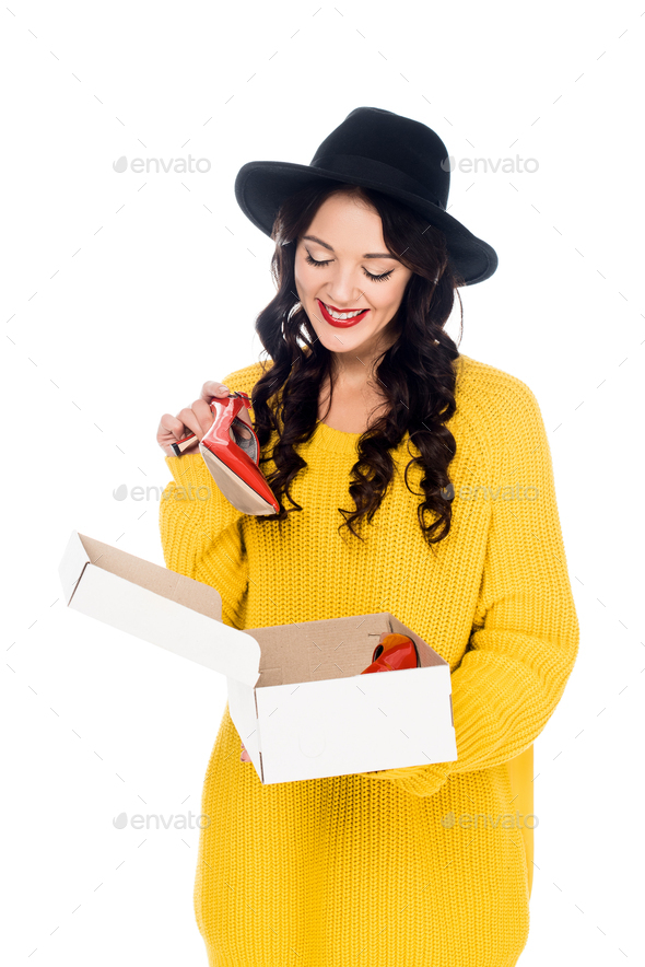 smiling woman holding footwear box with red high heels isolated on white