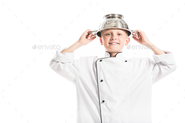 portrait of preteen boy in white chef uniform with colander on head isolated on white - Stock Photo - Images