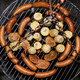 Baking sausages, sheeps cheese and corn on a metal grate fired with birch wood. - PhotoDune Item for Sale