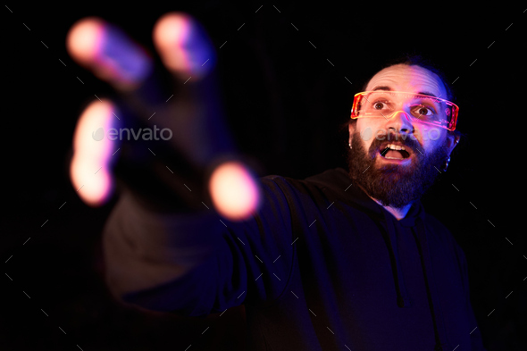 Portrait of an amazed man using a extended reality goggles and gesturing