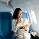 Asian female thinking about work in airplane concept Business traveling and technology concept - PhotoDune Item for Sale