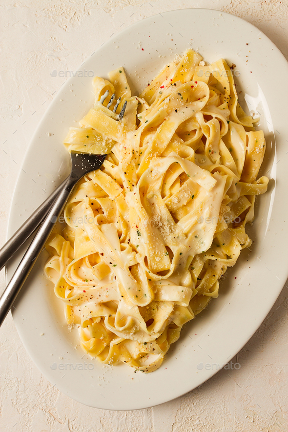 Fettuccine, tagliatelle, in creamy garlic sauce, Italian traditional ...