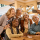 Cheerful group of seniors taking selfie with cell phone in residential care home. - PhotoDune Item for Sale