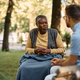 Black senior man talking to a healthcare worker at nursing home&#39;s park. - PhotoDune Item for Sale