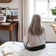 Rear view of senior woman sitting on a bed. - PhotoDune Item for Sale