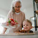 Grandmother giving homegrown strawberries to her little grandson. - PhotoDune Item for Sale
