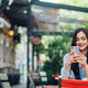 Portrait of a beautiful woman sitting in a street cafe and using a smartphone - PhotoDune Item for Sale