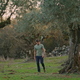 Serious farmer walking olive plantation. Calm man checking basket after harvest - PhotoDune Item for Sale