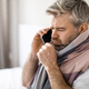 Sad sick man coughing while talking on the phone, closeup - PhotoDune Item for Sale