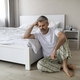 Frustrated middle aged man sitting on floor in bedroom - PhotoDune Item for Sale