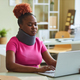 Black woman with neck brace working at desk in office using laptop - PhotoDune Item for Sale
