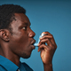 Black young man using asthma inhaler - PhotoDune Item for Sale
