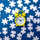 Yellow alarm clock and white puzzle on a blue background - PhotoDune Item for Sale