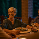 Happy senior woman talking to her family while having dinner on a patio. - PhotoDune Item for Sale