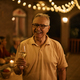Happy senior man having a glass of wine in the evening on a terrace and looking at camera. - PhotoDune Item for Sale