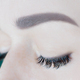 Close-up of closed eyes with artificial eyelashes, black eyeliner, ideal skin, eyebrows of - PhotoDune Item for Sale