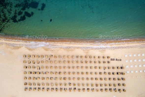 Aerial view of an stunning beach with wooden umbrellas, and calm sea. - Stock Photo - Images