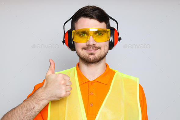 Young man civil engineer in ear protectors and goggles