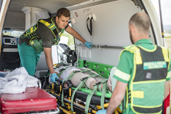 Paramedics moving car crash victim on stretcher Stock Photo by westend61