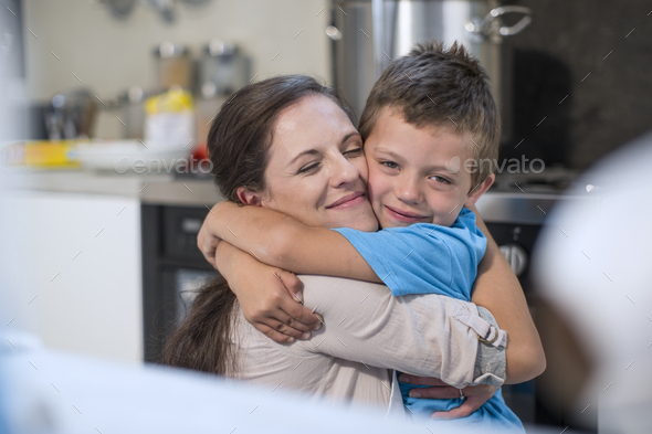 Mother and son hugging in kitchen Stock Photo by westend61 | PhotoDune