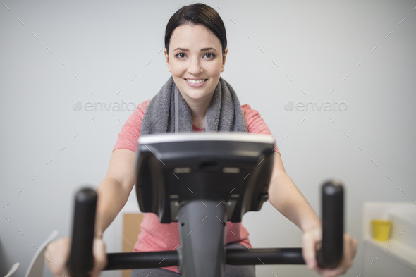 Smiling woman on exercise machine in medical practice