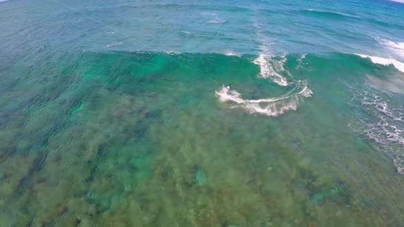 Aerial view of a man kitesurfing in Hawaii. alt
