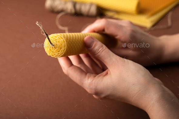Making candle from Beeswax honeycomb sheet on brown background - Stock Photo - Images