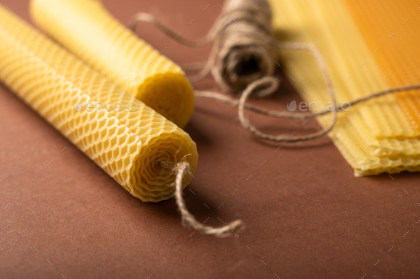 Making candle from Beeswax honeycomb sheet on brown background - Stock Photo - Images