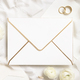 Blank envelope near cream roses, white silk ribbons and wedding rings top view, wedding mockup - PhotoDune Item for Sale