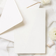 Blank card and envelope near cream roses and white silk ribbons top view, wedding mockup - PhotoDune Item for Sale