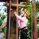 Girl climbing a rope trail in an adventure rope park. - PhotoDune Item for Sale