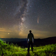 Dark silhouette of a man standing in mountains at night enjoying milky way - PhotoDune Item for Sale