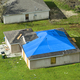 Top view of leaking house roof covered with protective tarp sheets against rain water - PhotoDune Item for Sale