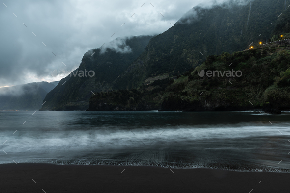 Famous volcanic black sand beach in Seixal, Madeira at dramatic cloudy weather - Stock Photo - Images