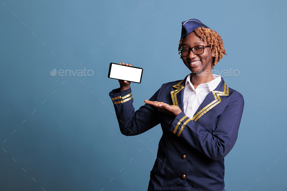 Female stewardess holding smartphone with white screen - Stock Photo - Images