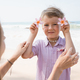 Little boy holding exotic flowers with mother at beach in sunny summer day - PhotoDune Item for Sale