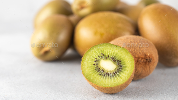 Green ripe kiwi half and whole on grey table. Place for text. Horizontal photo. - Stock Photo - Images