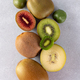 Different varieties of kiwi lie in a pile on the table. Halves of red, yellow, green kiwi - PhotoDune Item for Sale