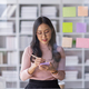 Young Asian woman Creative team use post it notes to share idea sticky note on glass wall. Asian  - PhotoDune Item for Sale