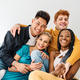 Multiethnic group of friends embracing at the sofa and smiling - PhotoDune Item for Sale